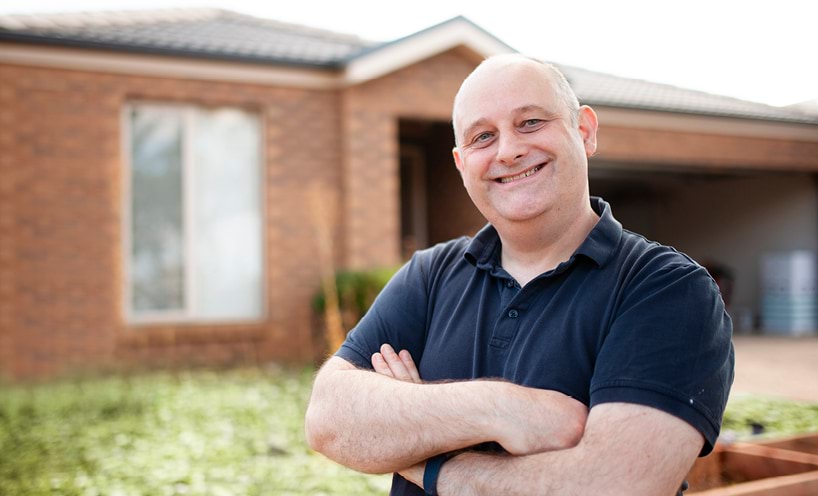 Man standing in front of his house with sola panels