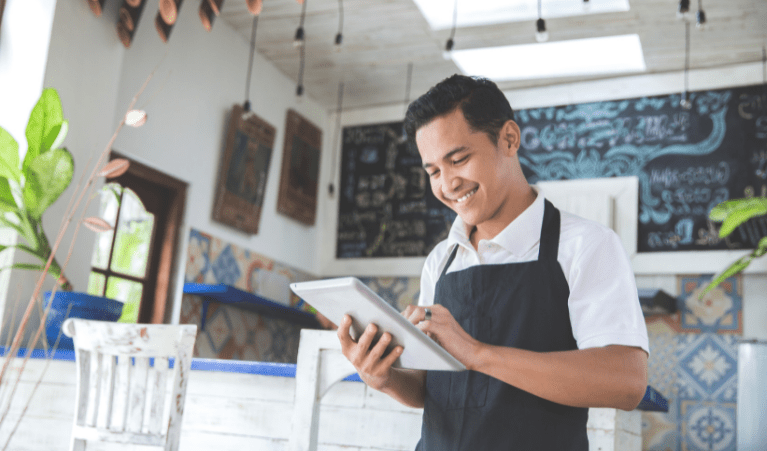 Portrait of young male cafe owner with tablet