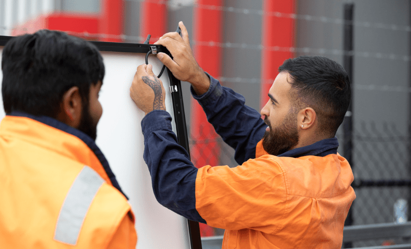 two installers are working wearing orange jacket