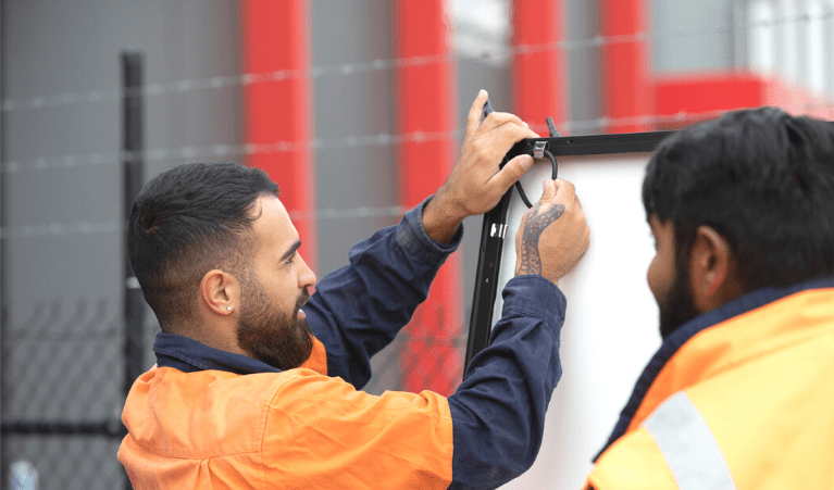 two installers are working wearing orange jacket