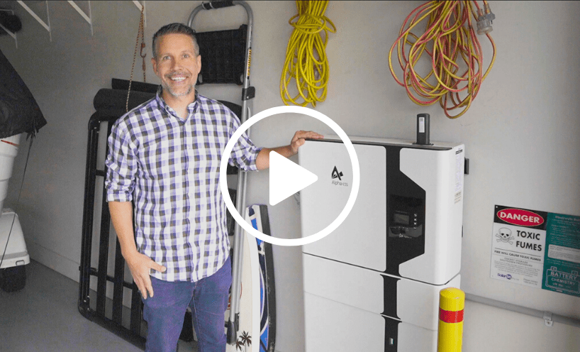 Patrick Sheehan is standing in his garage in front of his electric vehicle wall charger